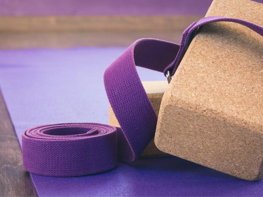 AlignWELL - Post Images (840x628) (2) A cork yoga block and purple strap rest on a yoga mat—essential props that support comfort and alignment in a gentle home yoga practice.